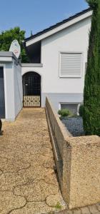 a white house with a gate and a driveway at Lunas FeWo in Römerberg