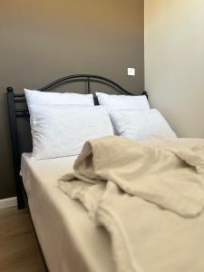 an unmade bed with white sheets and pillows at Luna Home in Jermuk