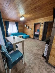 a living room with a blue couch and a table at Cabana Deliuta in Cavnic