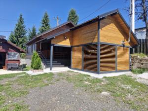 a house with a wooden garage in a yard at Cabana Deliuta in Cavnic