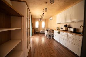 a kitchen with wooden floors and white cabinets at Casa Oliva Tokaj in Tokaj