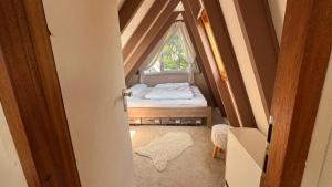 a small attic room with a bed and a window at Gemütliches Ferienhaus in der Eifel mit Pool, Tennisplatz, Minigolf und nahem See in Blankenheim +19 photos