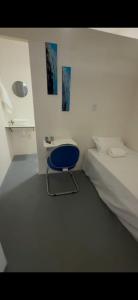 a bedroom with a blue chair next to a bed at COP30 hospedagem in Belém