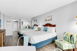 ein Hotelzimmer mit zwei Betten und einem Tisch und Stühlen in der Unterkunft WINTER RATES! OceanviewStudio Full Kitchen, Dogs OK! 1128 in Myrtle Beach + 20 Fotos