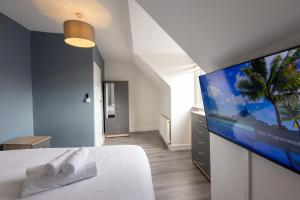 a bedroom with a bed with a flat screen tv at Large 4-Bedrooms Corporate Flat, Free Parking - Amazing Location in Leavesden Green