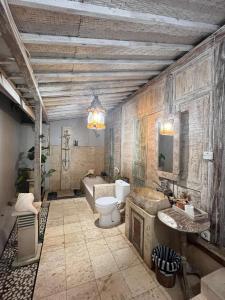 une salle de bain avec toilettes, lavabo et baignoire dans l'établissement Secret Wooden Cabin - Lilac Suite, à Jimbaran