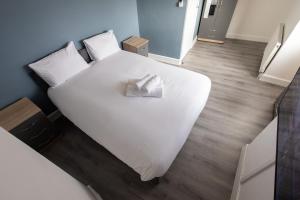 a white bed with a napkin on it in a room at Large 4-Bedrooms Corporate Flat, Free Parking - Amazing Location in Leavesden Green