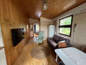 a living room with a couch and a tv at Semi-detached cottage by the lake in Jyväskylä