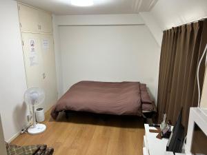 福岡市にあるOhori Park INNの小さなベッドルーム(ブラウンの毛布付きのベッド付)