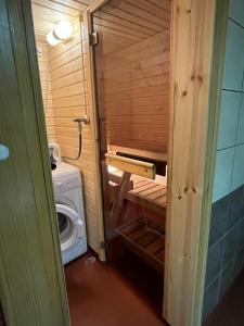 ein kleines Bad mit einer Waschmaschine und einer Waschmaschine in der Unterkunft Semi-detached cottage by the lake in Jyväskylä + 19 Fotos