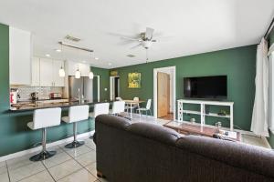 a living room with a couch and a kitchen at Coastal Getaway in Seminole