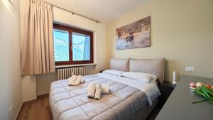 a bedroom with a large bed with two pillows on it at Hostdomus - Rainbow Apartment in Sestriere