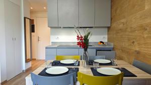 a dining room table with chairs and a vase of flowers at Hostdomus - Rainbow Apartment in Sestriere
