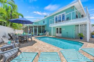 a villa with a swimming pool and a house at Lantana - 5251A in Siesta Key