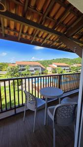 a patio with a table and chairs on a balcony at Club Meridional Carneiros 01PS Pé na Areia by LP in Tamandaré