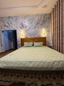 a bedroom with a large bed with a marble wall at Hillside House in Kigali