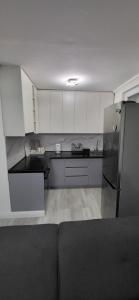 a kitchen with white cabinets and a stainless steel refrigerator at Apartman Lala in Sarajevo