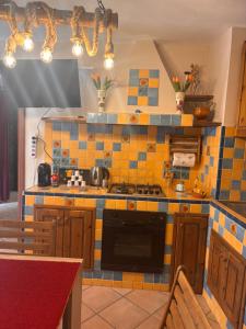 a kitchen with yellow and blue tiles on the counters at La casetta di Nonna Rosa in Santa Domenica