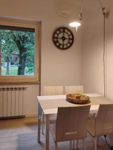 イスプラにあるHomely Ispraのダイニングルーム(テーブル、壁掛け時計付)