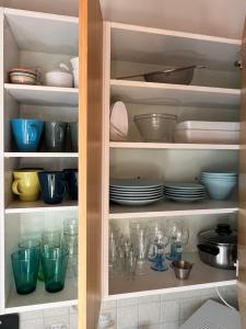 a cabinet filled with dishes and bowls and plates at Semi-detached cottage by the lake in Jyväskylä
