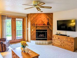 a living room with a fireplace and a ceiling fan at UpperDells Riverfront Jacuzzi, Pool and Hot Tub in Wisconsin Dells