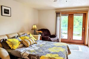 a bedroom with a bed and a chair and a window at UpperDells Riverfront Jacuzzi, Pool and Hot Tub in Wisconsin Dells +21 photos