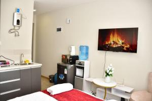 a room with a bed and a kitchen with a fire on the wall at Rieyo Homes Studio near Airport and SGR Train Station in Nairobi