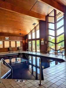 a large swimming pool in a building with windows at UpperDells Riverfront Jacuzzi, Pool and Hot Tub in Wisconsin Dells