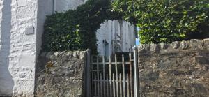 a stone wall with a gate in front of a building at Yeomans Cottage in Pitlochry