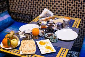a table with breakfast foods and orange juice on it at Dar Omar in Fez