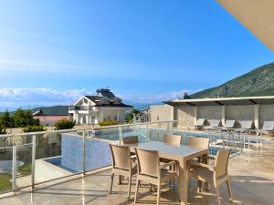 Un patio con una mesa y sillas en un balcón. en Villa Panorama View Oludeniz, en Fethiye