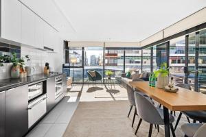 a kitchen and dining room with a table and chairs at Serrata - 2B2B Docklands Apt Parking Available in Melbourne