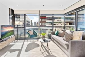 a living room with a couch and a large window at Serrata - 2B2B Docklands Apt Parking Available in Melbourne