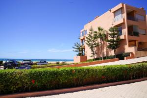 伊米乌阿达尔Oceanfront Gem and Beach Access的一座有车停在海洋前的建筑