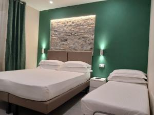 two beds in a room with green walls at Affittacamere CINQUE TERRE LABI in La Spezia
