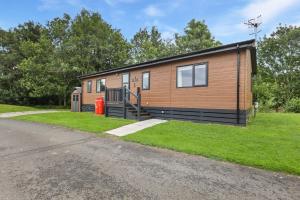a tiny house on the side of a road at Woodland View Lodge - North East Escapes in Wooler