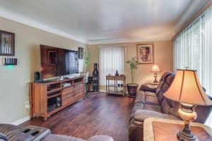 a living room with a couch and a flat screen tv at Detroit Retreat with Gazebo Fire Pits and Charcoal Grill in Detroit