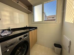 - une buanderie avec un lave-linge et un évier dans l'établissement Apto Alto Padrão Aviação 2Qts (1Suíte), à Praia Grande 32 autres photos