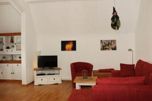 a living room with a red couch and a tv at Hexnquartier in Braunlage