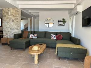 a living room with a green couch and a table at Casa Manuela in Montefrío