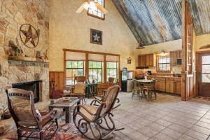 a living room with chairs and a stone fireplace at SisterCreek Ranch - Other Cabin in Boerne +46 photos