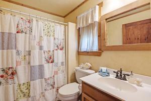 a bathroom with a toilet and a sink and a mirror at SisterCreek Ranch - Other Cabin in Boerne