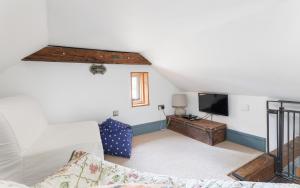 Una sala de estar con un sofá y un televisor. en The Little Dairy Park Farm - Charming Countryside Retreat on the Isle of Wight, en Ryde