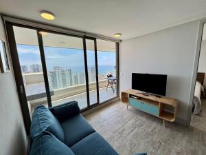 un soggiorno con un divano blu e una grande finestra di Confortable depto con amplia vista a Concón