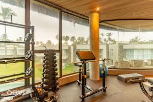 einen Fitnessraum mit Blick auf ein Gebäude in der Unterkunft Casa Anamá em condomínio Naluum H9 by Qavi in Passo de Camarajibe