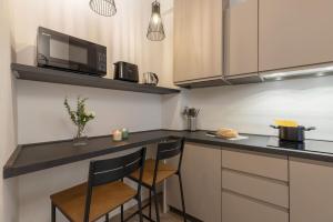 a kitchen with a counter with two chairs and a microwave at Bijoux Suite near Boboli Gardens in Florence