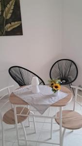 a table with two chairs and a table with flowers on it at White House in Sassari
