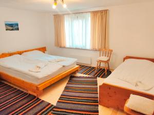 a bedroom with two beds and a chair in it at Калиновата къща in Stoykite