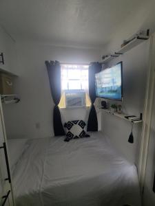 a small room with a bed and a tv at Cozy Escape in Charlestown +61 photos