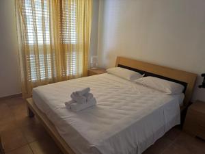 a white bed with two teddy bears on it at Basilicata Host to Host - Maranna Apartment in Policoro